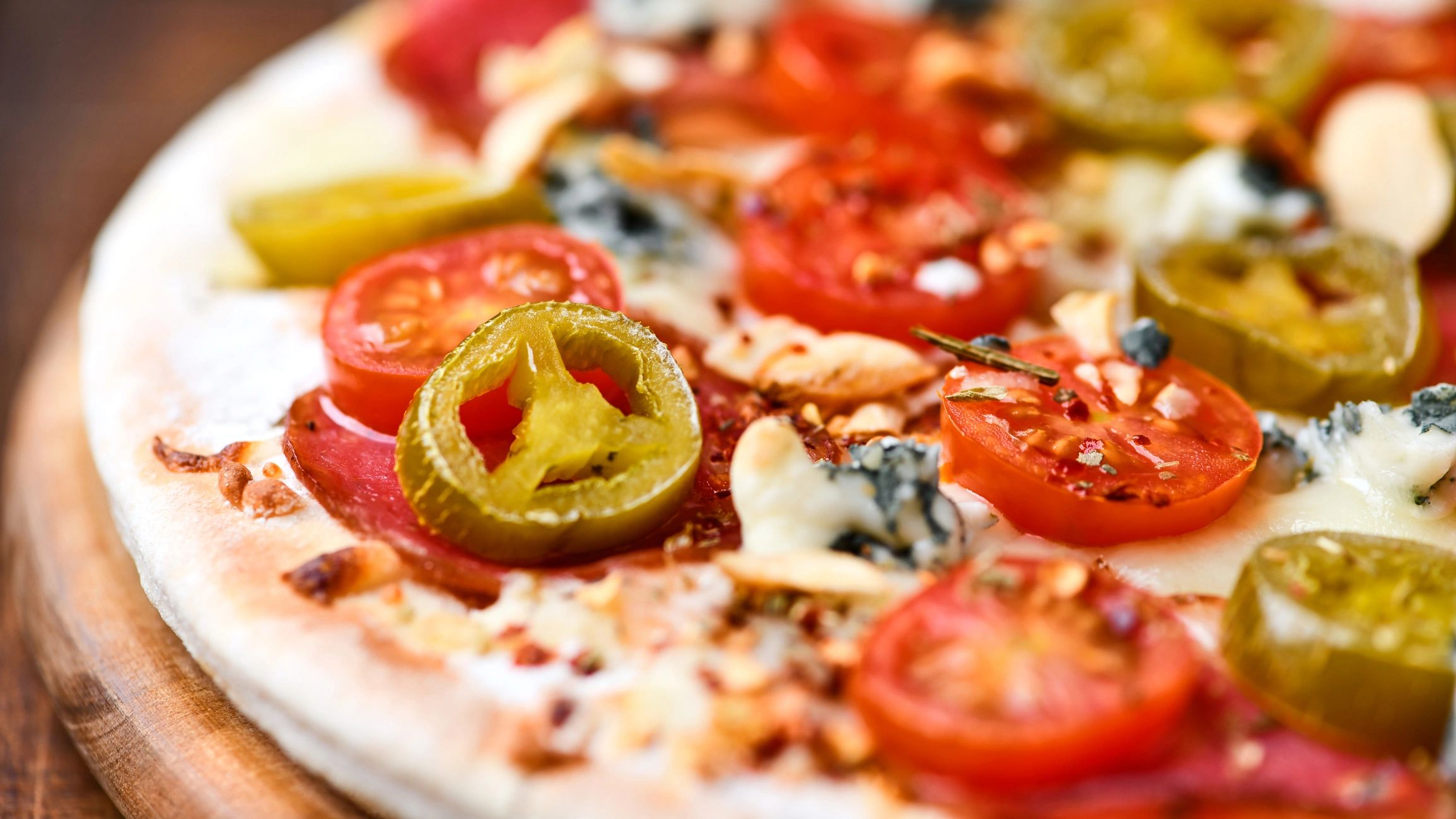 Pizza with jalapeno, cherry tomatoes, and mozzarella